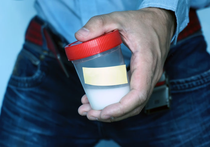 close-up semen in left hand of asian man in bathroom