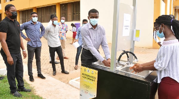 Three Engineering students build automatic hand washing station. 1