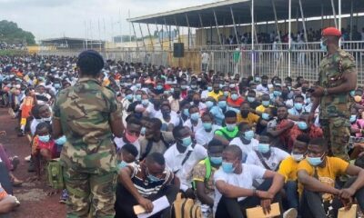Disappointed GAF applicants holding documents in protest outside a government office after the 2021 recruitment delay.