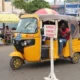 Ghanaian Pragya riders parked near a busy market under police watch