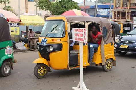 Ghanaian Pragya riders parked near a busy market under police watch