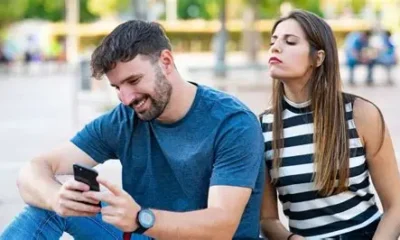 Suspicious woman checking her partner’s phone secretly