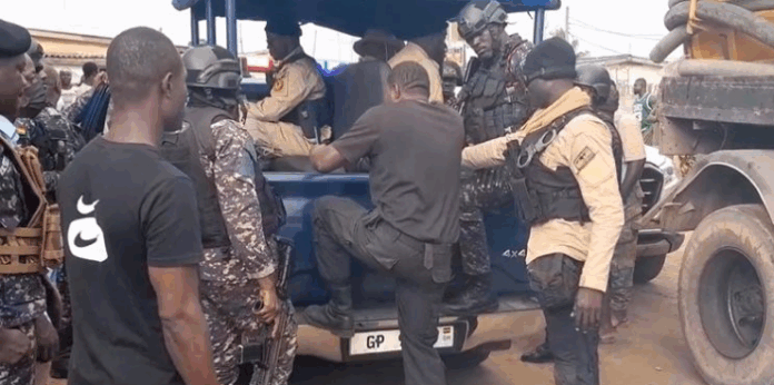 Police officers arrest men posing as fake security personnel near Awoshie polling station