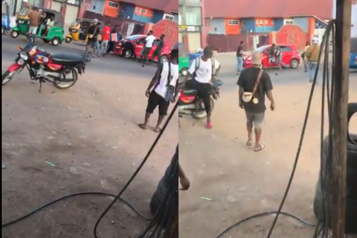 Two men exchange punches in a heated street fight as bystanders attempt to separate them.