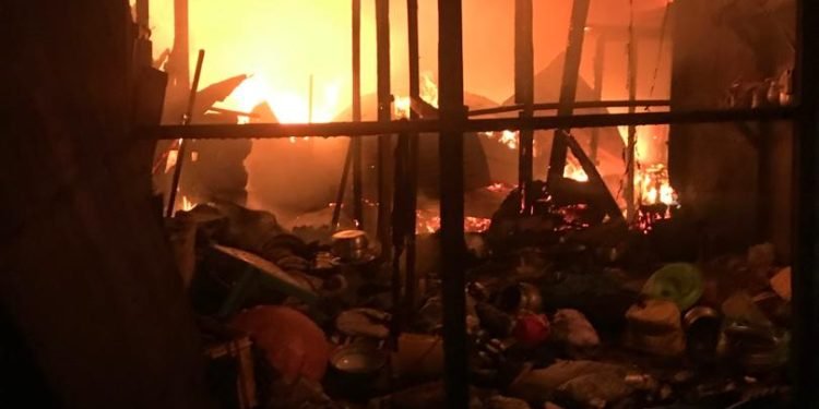 Firefighters battle Madina Market fire in Accra as shops and wooden structures burn.